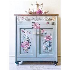 a blue cabinet with flowers painted on it