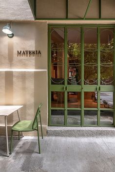 a green chair and table in front of a building