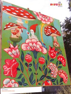 a large sign with flowers and mushrooms painted on it