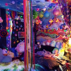 a room filled with lots of stuffed animals and balloons hanging from the ceiling above it