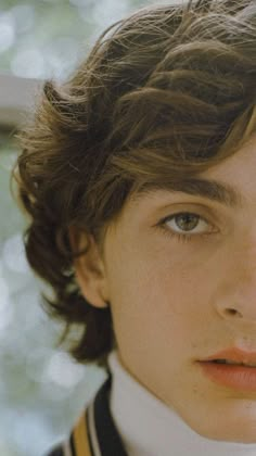 a close up of a young person wearing a collared shirt and looking at the camera