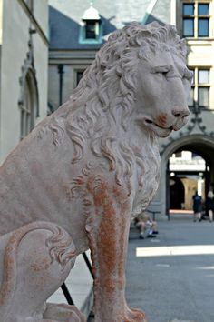 a statue of a lion sitting in front of a building