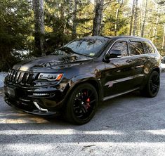 a black jeep parked in front of some trees