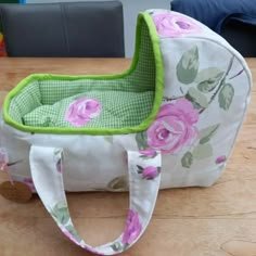 a flowered bag sitting on top of a wooden table