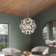 a dining room table with chairs and a chandelier hanging from it's ceiling