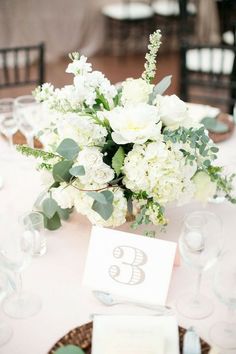 the table is set with white flowers and place cards