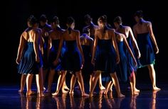 a group of women standing on top of a stage wearing different colored dresses and shoes