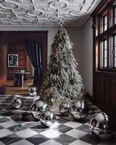 a christmas tree with silver balls on the floor