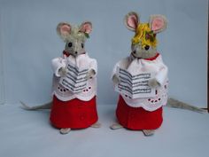 two mouse mice are dressed in red and white outfits, one is reading a book