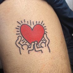 a tattoo on the back of a man's leg with two hands holding a heart