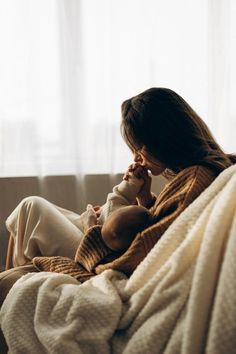 a woman sitting on a couch holding a baby