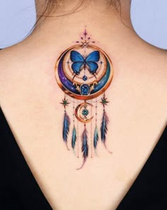 the back of a woman's neck with a butterfly and moon tattoo on it