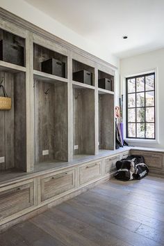 an empty room with wooden shelves and shoes on the floor