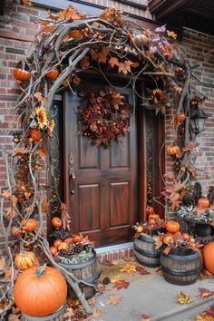 a front door decorated with pumpkins and vines