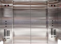 two stainless steel elevators with buttons on each side and numbers on the doors,