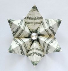 an origami star made out of dollar bills with a diamond in the center