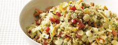 a white bowl filled with rice and veggies on top of a checkered table cloth