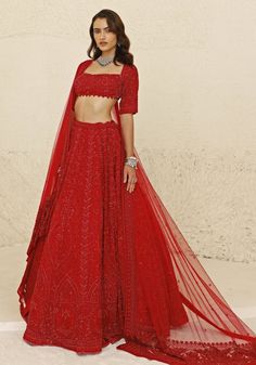 Radiate opulence with a stunning Crimson Red Bridal Lehenga Set, meticulously crafted from luxurious georgette. The red lehenga is adorned with intricate nalki and beaded embroidery in a harmonious red hue, adding depth and sophistication to the ensemble. Teamed with a Florentine neckline blouse featuring delicate bead detailing at the waistline, this set exudes elegance and refinement. Completing the look is a net fabric dupatta, embellished with a heavy hand-embroidered border, enhancing the overall allure. This bridal lehenga is a perfect choice for your special day. Composition : Lehenga, Blouse & Dupatta : Georgette, Net Care: Dry Clean Only and Vacuum Storage This product can be customized for sleeves, length and colour Delivery : 8-10 weeks as the product is hand crafted. Check Size Red Embellished Georgette Sets, Red Embellished Georgette Sharara, Red Embellished Sharara For Navratri, Red Georgette Sharara For Reception, Red Georgette Choli With Cutdana, Red Embellished Floor-length Saree, Red Embellished Georgette Saree, Red Embellished Saree For Reception, Red Georgette Lehenga For Navratri