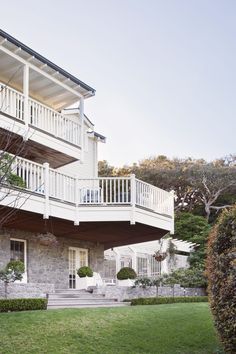 a large white house with two balconies on the second story