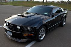 a black mustang parked in a parking lot