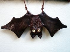 a bat hanging on the wall with eyes drawn on it's back and wings