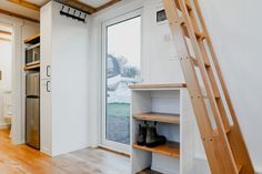 an empty room with open shelves and wooden stairs leading up to the lofted bedroom