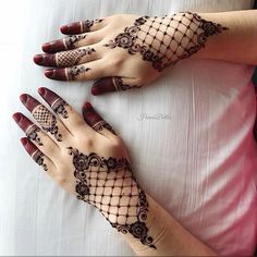 two hands with henna tattoos on them