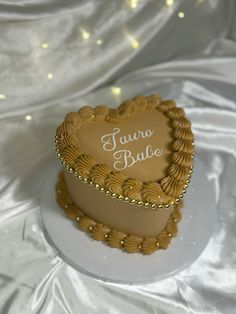 a heart shaped cake with the words tauro bake on it sitting on a white plate