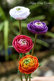 three crocheted flowers are in a vase