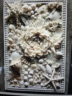 an art piece made out of shells and flowers