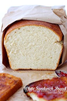 a loaf of bread sitting on top of a table next to some slices of bread