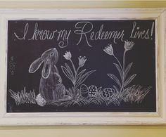 a chalkboard drawing of a bunny sitting in the grass