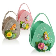 three small purses with flowers and fairy tinker bags on them, one has a flower in the center