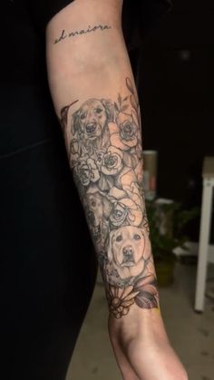 a woman's arm with flowers on it and a dog in the middle of her arm