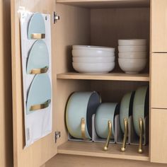 an open cabinet with plates and bowls in it