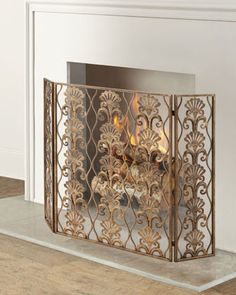 an ornate fireplace screen with flames burning in it's center, on the floor