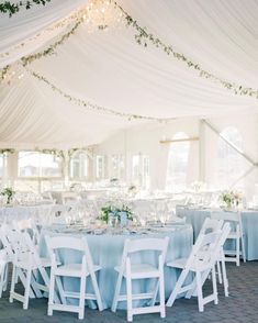 the tables and chairs are set up for a wedding reception in a tent with white draping