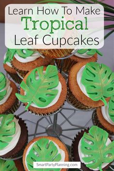 cupcakes with green frosting and palm leaves on top are arranged in a pyramid