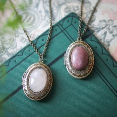 13x18mm oval cabochon stone on a vintage brass, antiqued or shiny silver-plated 24x30mm oval locket.  Perfect for remembering your loved ones.  On 28 inches of antiqued brass or stainless steel chain.  I can change the chain to any length, just leave a note at checkout. Choose from Rose Quartz or Rhodonite. Choose Antiqued brass, antiqued silver plated, or shiny silver plated setting. Great for pictures of your loved ones.  Simply print, cut out and attach a photo with glue.  We do not offer pri Oval Cameo Keepsake Jewelry, Oval Cabochon Brass Necklace, Antique Silver Necklaces With Oval Vintage Charm, Antique Silver Necklace With Vintage Charm, Antique Silver Necklace With Vintage Charm In Oval Shape, Antique Silver Oval Necklace With Vintage Charm, Spiritual Bronze Oval Jewelry, Spiritual Oval Bronze Jewelry, Victorian Oval Nickel-free Necklaces