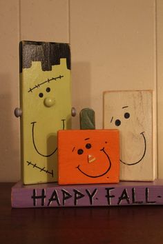 three wooden blocks with faces painted on them