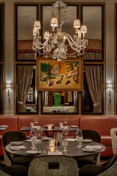 a dining room with chandelier, table and chairs