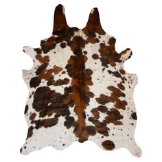 a brown and white spotted cowhide rug on a white background, with two horns sticking out of it