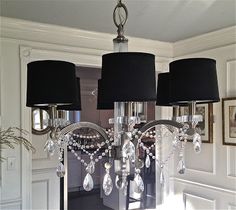 a chandelier with black shades and crystal beads hanging from it's sides