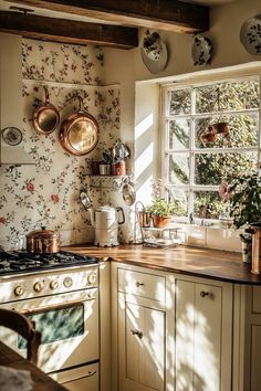 an old fashioned kitchen with pots and pans on the window sill above the stove