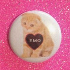 a button with an emo dog holding a heart on it's chest and the word emo written in black