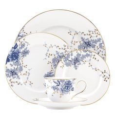 a blue and white china dinnerware set with flowers on the plate, cup and saucer