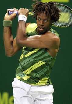 a man with dreadlocks holding a tennis racket