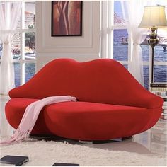 a red couch sitting on top of a white rug