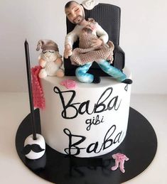 there is a cake with two people sitting on the chair and one person holding a baby