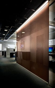 an office cubicle with a metal screen on the wall